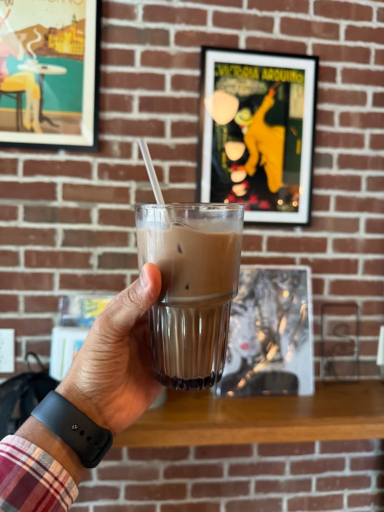 Iced latte by the poster wall